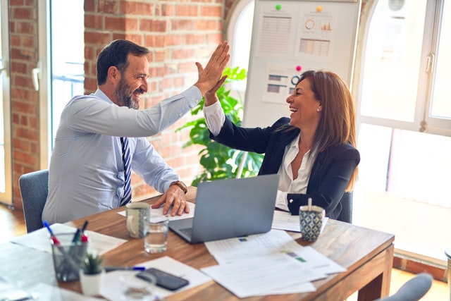 a man giving a high-five to a woman at work