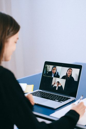 A GIRL ATTENDING A VIRTUAL MEETING AT THE WORKPLACE