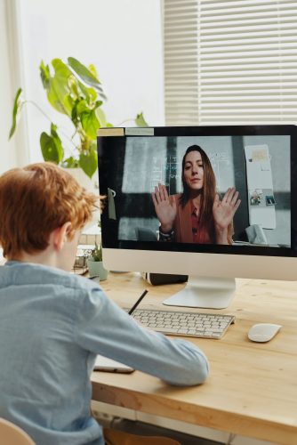 A child actively listening to a lady communicating on computer 