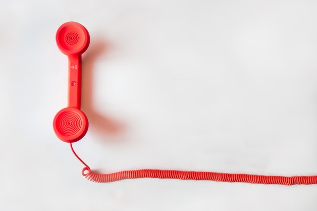 A red colored phone depicting contact