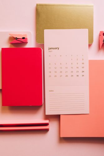 Pink notepad alongside Calendar to organize work shown as a skill for work from home job