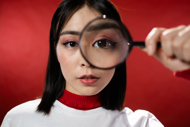 a girl looking through a magnifying glass depicting critical observation skills