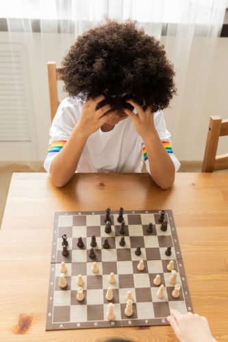 a child applying critical thinking skills while playing chess