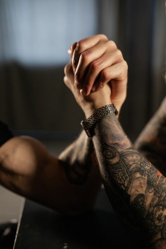 Two hands fisting in a competition on a table.