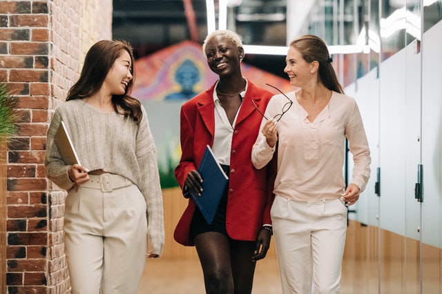 THREE GIRLS SHOWING AMICABLE BEHAVIOR AT WORKPLACE