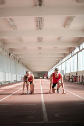 The image shows two people running in a competitive manner.