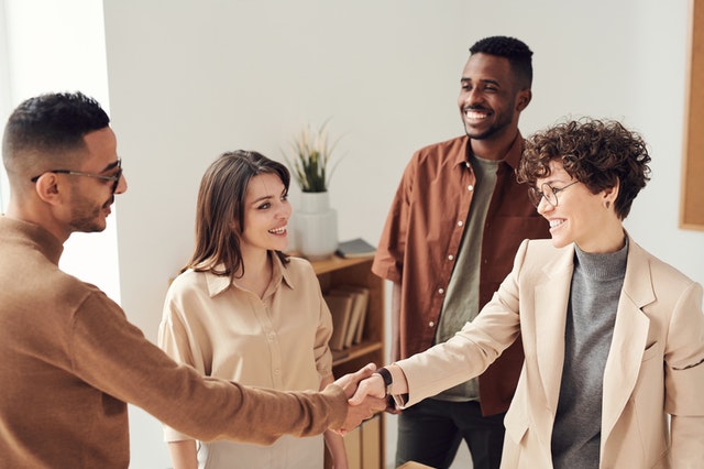 Two people handshaking and maintaining eye-contact as highlighting business etiquette rules