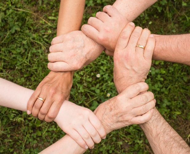 The image shows people holding hands depicting collaboration skills