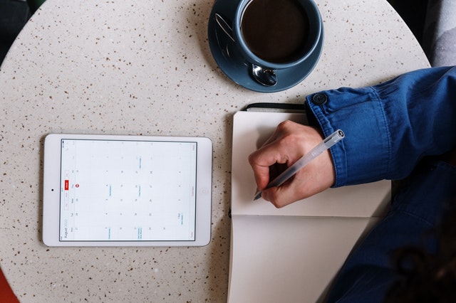 A person scheduling his tasks with help of calendar